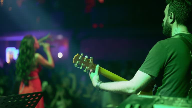 Musicians singing and playing guitar on stage show