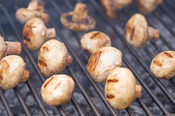 Mushrooms are cooked on the grill. Delicious mushrooms on the fire. stock photo