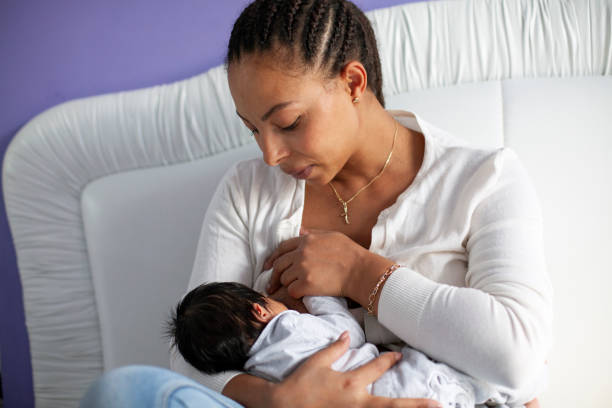 African American Woman Breastfeeding A Newborn Baby stock photo
