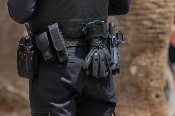 Police security belt - showing pepper spray, baton, gloves, walkie talkie and body armour. stock photo