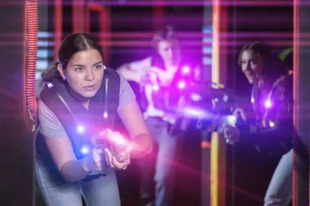 Photo of Girl running and dodging while playing lasertag