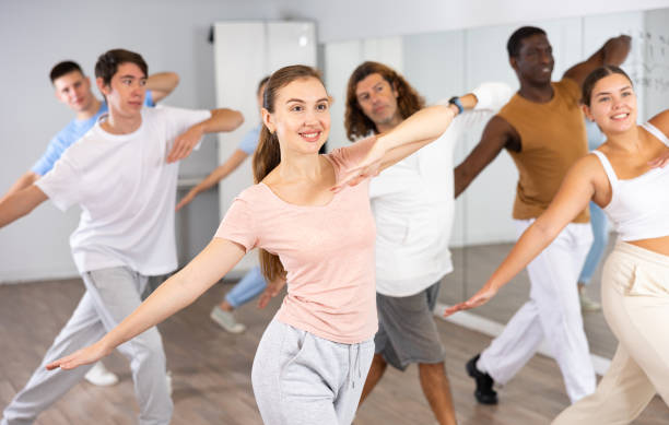 istock Happy active energetic multiracial dancers of different ages dancing aerobics at lesson in modern class studio 1494936920