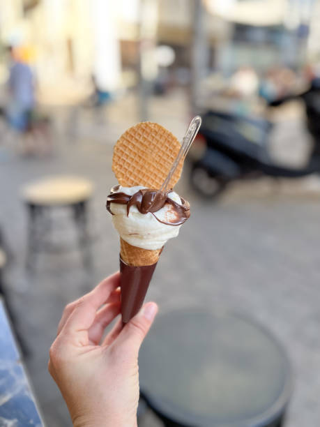 istock ice cream in a cone with chocolate holding by a hand 1494938039