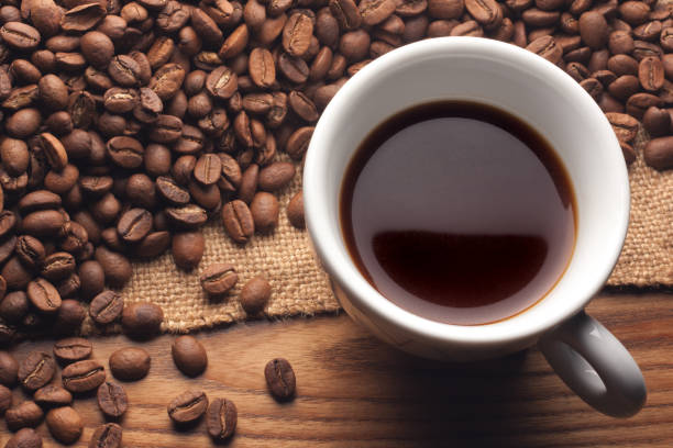 istock Cup black coffee. Roasted beans on sack on wooden table. 1494939151