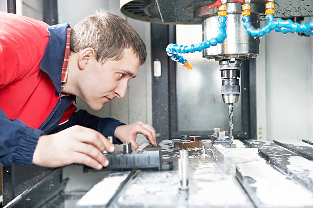 worker operating CNC machine center mechanical technician operative of cnc milling cutting machine center at tool workshop milling machine stock pictures, royalty-free photos & images