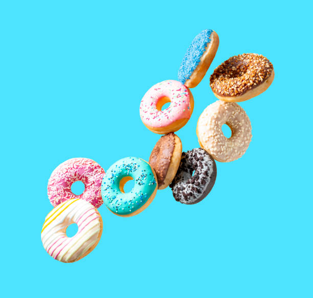 istock Sweet donuts of different colors in flight on a blue background 1494950698