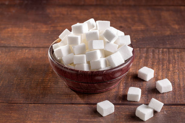 istock White sugar cubes in wooden bowl. 1494952792