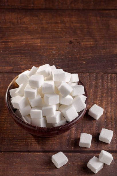 istock White sugar cubes in wooden bowl. 1494952808