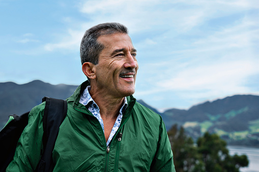Portrait of an older man smiling on the mountain.