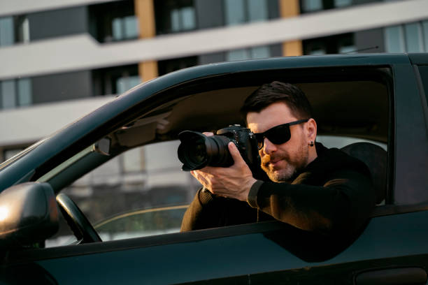 istock Man detective or agent taking photos from the car, wearing modern sunglasses 1494958708