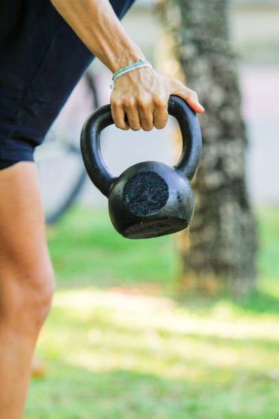 Woman holding a kettlebell at an outdoor functional workout in Rio de Janeiro.