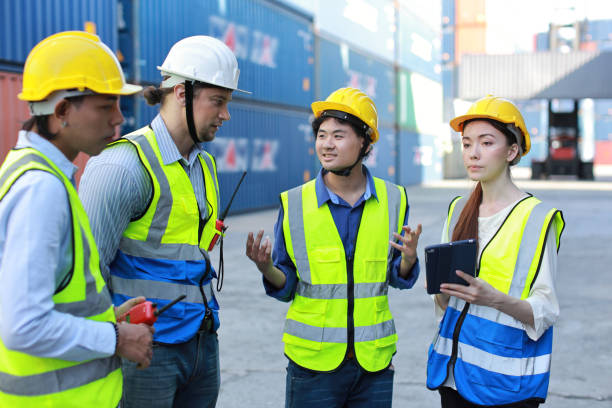 istock Group of multiethnic technician engineer and businessman in protective uniform standing and discussing, researching, brainstorming and planning work together with tablet at container cargo site 1494966162