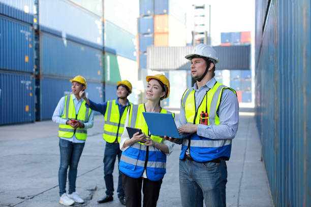 istock Group of multiethnic technician engineer and businessman in protective uniform standing and discussing, researching, brainstorming and planning work together with computer at container cargo site 1494966178