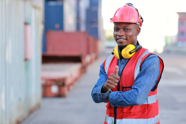 istock Foreman engineer standing and crossed arms while showing thumb up with happy and success face. Confident engineering work at container cargo site and checking industrial container cargo freight ship 1494967019
