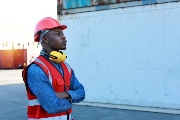 istock Foreman engineer standing and crossed arms while looking away with happy and success face. Confident engineering work at container cargo site and checking industrial container cargo freight ship 1494967214