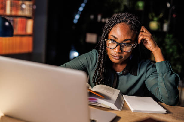 istock Tired female student taking notes and studying at her desk late at night 1494967462