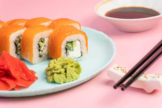 Japanese food concept. Sushi roll Philadelphia with salmon and cream cheese on a plate with ginger and wasabi. Sushi menu. Japanese traditional cuisine. asianfood.