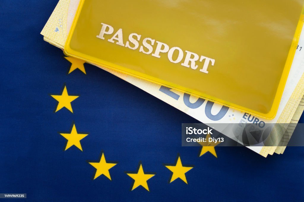 Flag of european Union with passport. Travel visa and citizenship concept. residence permit in the country. a yellow document with the inscription passport is on flag. Close up, top view Flag of european Union with passport. Travel visa and citizenship concept. residence permit in the country. a yellow document with the inscription passport is on the flag. Close up, top view Passport of the European Union Stock Photo
