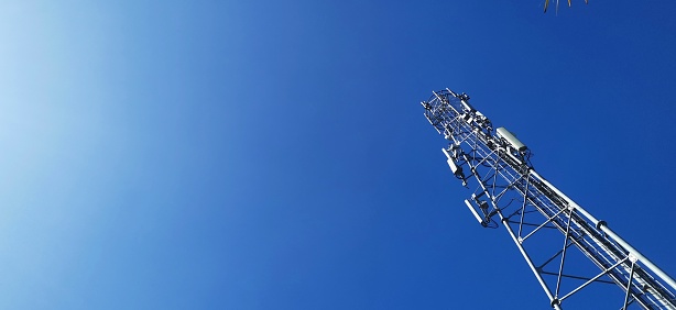 Telecommunications communication tower with a clear blue sky as a background.