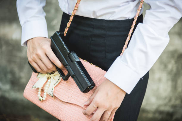 istock Young woman self defence putting gun 1494984653