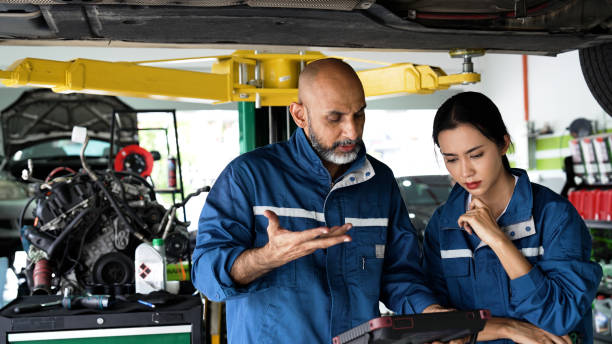 istock Asian senior mechanic and female apprentice diagnosing vehicle for issues 1494985652