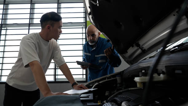 istock Asian male having a conversation with auto mechanic for his car servicing 1494985706