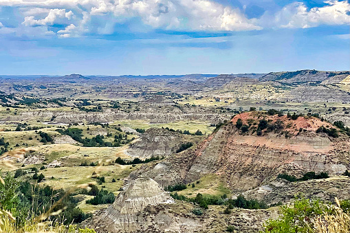 An upward facing view of the Notch Trail at Badlands National Park in South Dakota during the day with cumulus clouds in the sky.