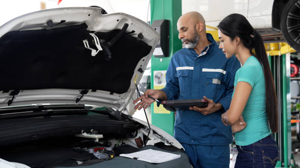 istock Asian female having a conversation with auto mechanic for his car servicing 1494985822