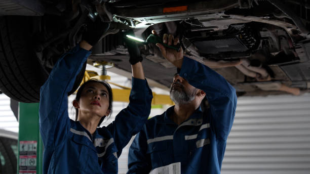 istock Asian senior auto mechanic focused at work with female trainee 1494985919