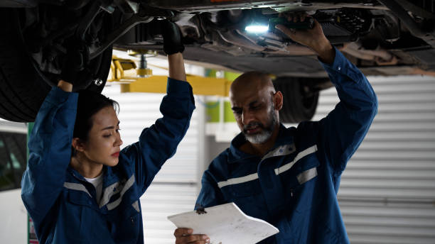 istock Asian senior auto mechanic focused at work with female trainee 1494985933