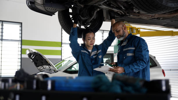 istock Asian senior auto mechanic focused at work with female trainee 1494985935