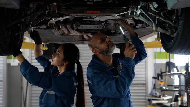 istock Asian senior auto mechanic focused at work with female trainee 1494985938