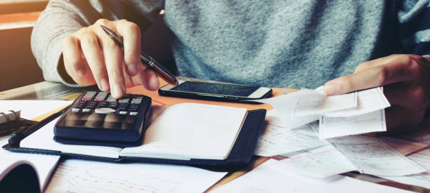 istock Man using calculator and calculate bills in home office. 1494988270
