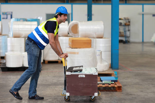 istock Warehouse  worker pulling a pallet truck and taking or upload package box to shelf in large warehouse. Active caucasian business manager controlling work at warehouse industry building. 1494988448