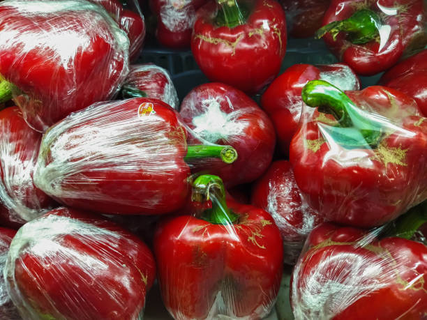istock Bunch of plastic wrapped red bell peppers. Red paprika. 1494990205