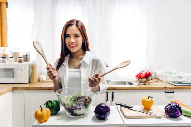 istock Woman cooking mixing salad in kitchen 1494994214