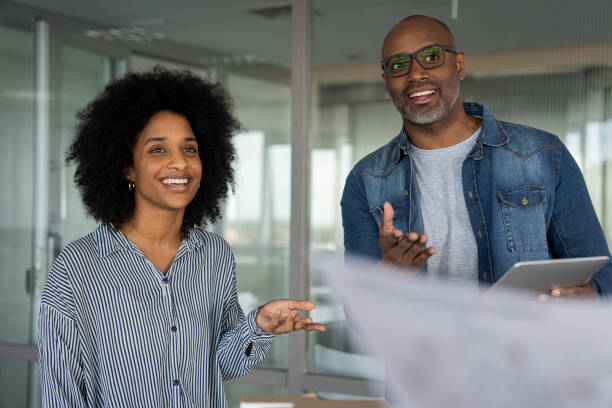 istock Female African American architect and her male partner making project presentation 1494994678