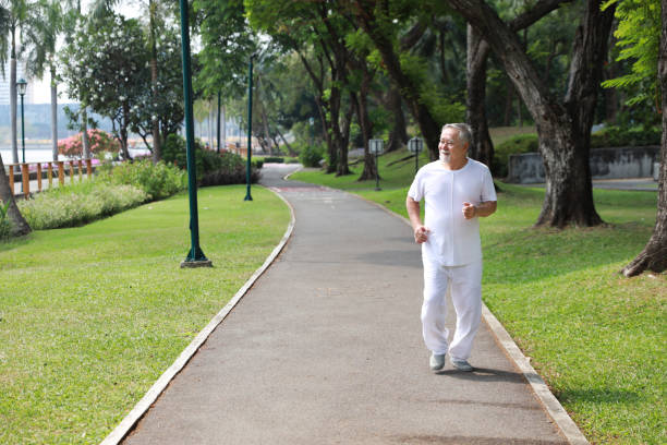 istock Happy and smiling asian senior man doing exercise and jogging or walking with relaxation for healthy in park outdoor after retirement during summer time. Health care elderly outdoor lifestyle concept. 1494995789