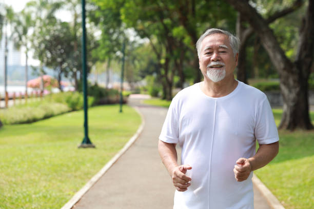 istock Happy and smiling asian senior man doing exercise and jogging or walking with relaxation for healthy in park outdoor after retirement during summer time. Health care elderly outdoor lifestyle concept. 1494995793