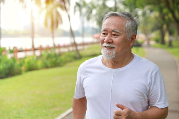 istock Happy and smiling asian senior man doing exercise and jogging or walking with relaxation for healthy in park outdoor after retirement during summer time. Health care elderly outdoor lifestyle concept. 1494995794