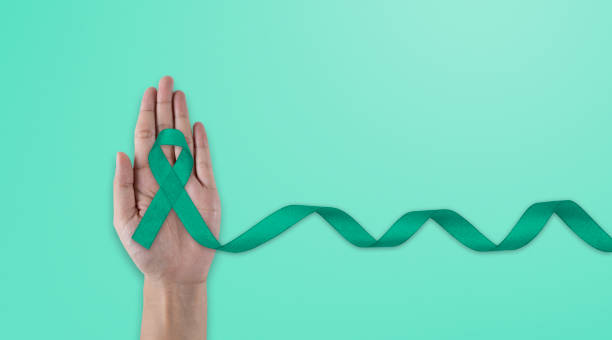 istock Hands holding emerald green or jade green ribbon on white fabric background with copy space, symbol for Liver Cancer awareness, World Cancer Day. Healthcare 1494997996