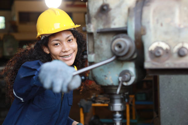 istock Technician engineer or worker woman in protective uniform with safety hardhat maintenance operation or checking lathe metal machine at heavy industry manufacturing factory. Metalworking concept 1495001160