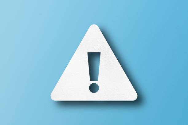 istock White paper punched into the shape of an exclamation mark. warning sign Set on a light blue paper background. 1495006908