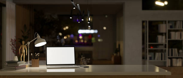 istock Modern office at night with laptop mockup on a tabletop. 1495007247