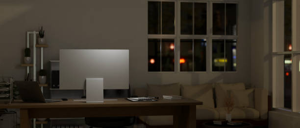 istock Modern contemporary office at night with computer and office supplies on table. 1495007294