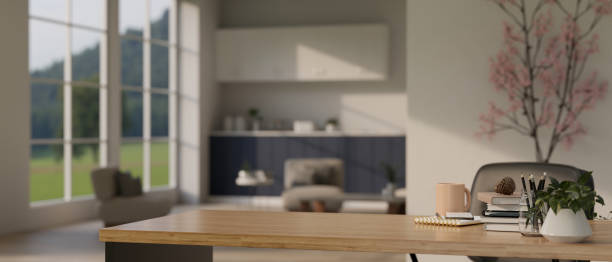 istock Empty mockup space on a wooden working table over blurred background of a modern living room 1495007316