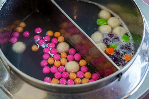 Colorful Tang Yuan cooking in boiling water, a traditional dish prepared for Chinese New Year