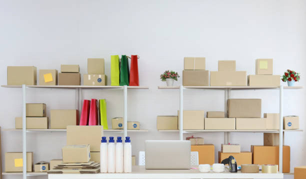 istock Computer on wooden working table with package product box delivery background in room in apartment indoor. Startup small business SME concept 1495011208