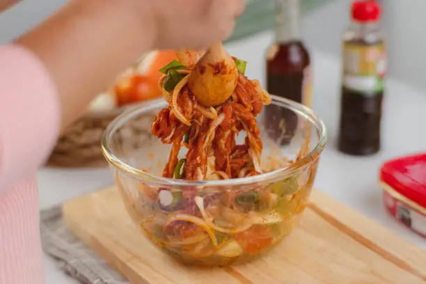 Photo of Step-by-step procedures to marinate pork for easy Korean cooking, add chopped onions and Japanese bunching onion, sesame oil, soy sauce, Korean gochujang and mix well. Korean homemade food for lunch