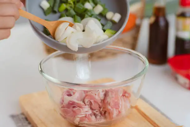 Photo of Step-by-step procedures to marinate pork for easy Korean cooking, add chopped onions and Japanese bunching onion, sesame oil, soy sauce, Korean gochujang and mix well. Korean homemade food for lunch